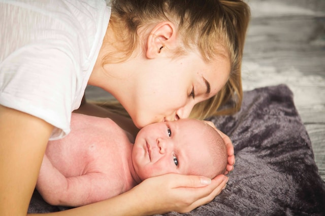 Maman faisant un bisou à son bébé lors d'une séance de massage bébé.